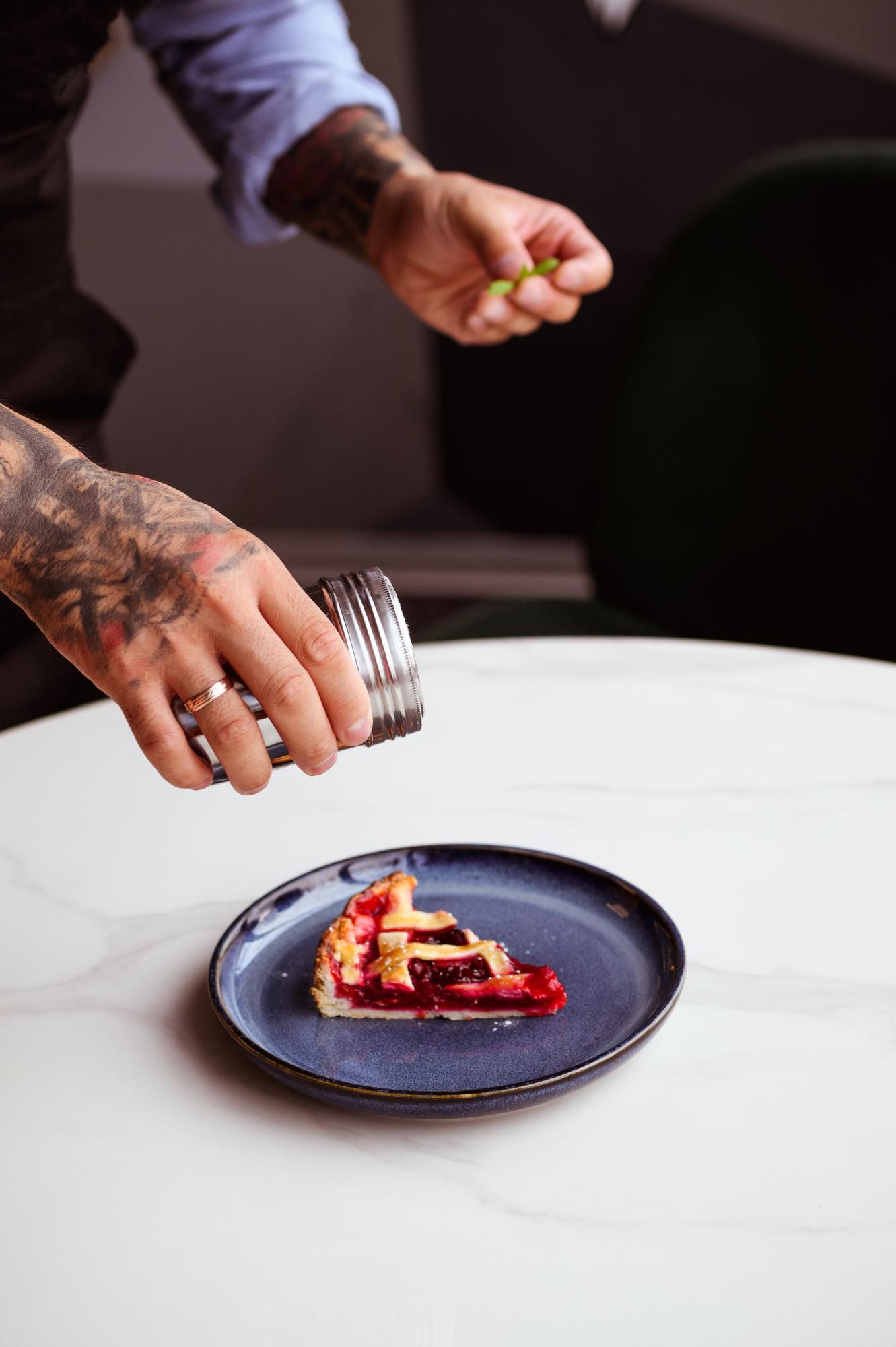 Chef arranging plated tasting menu on wooden table